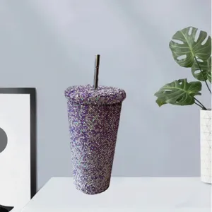 Close up detail of purple rhinestone bling studded tumbler cup with straw for stylish daily drinks.