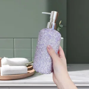 Detail shot of a sparkling purple rhinestone soap dispenser bottle held in hand, bathroom setting.