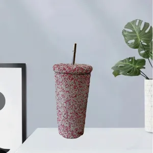 Detailed view of the sparkling rhinestone tumbler with straw, elegant desktop presentation.