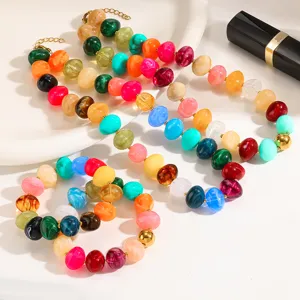 Detailed shot of colorful rainbow acrylic beaded necklaces and bracelets with gold spacers.