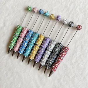 Detailed view of colorful DIY rhinestone beaded pens with sparkling pearls and metal tips.