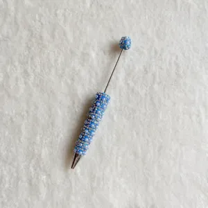Detailed view of handmade blue rhinestone beaded pen with sparkling pearls and metal stem.