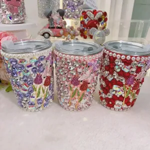 Detailed view of handmade rhinestone bling straw tumbler featuring butterfly and tulip crystal art.