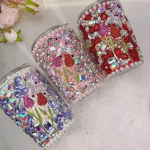 Handmade rhinestone tumbler cups featuring sparkling butterfly and tulip designs with pearl trim.