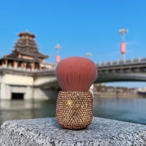 Detailed view of the pink fluffy mushroom makeup brush with sparkling rhinestone handle.