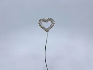 Close up detail of rhinestone heart balloon car ornament with sparkling crystal studs.