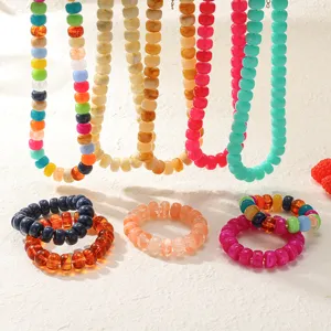Dettaglio di gioielli di perline in acrilico colorato, set di collana e bracciale vibrante.