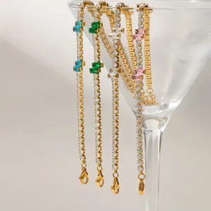 Close-up detail of colorful cubic zirconia gold tennis bracelets hanging inside a glass.