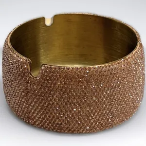 Primo piano del lussuoso posacenere con strass scintillanti, interno dorato e due fessure.