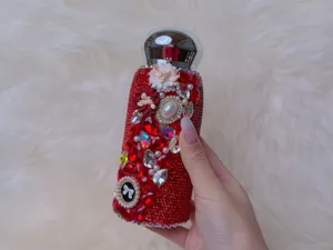 Close-up detail shot of a sparkling red rhinestone insulated tumbler decorated with pearls and flowers.