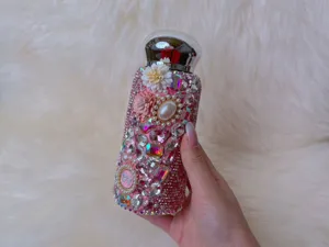 Close-up detail of 304 stainless steel rhinestone daisy thermos cup, sparkling pink style.