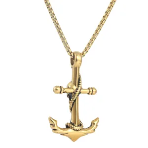 Close-up detail shot of the golden stainless steel anchor and skull pendant necklace.