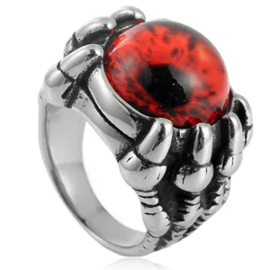 Stainless steel punk dragon claw demon eye ring close up, gothic red gem mens jewelry.