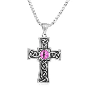 Stainless steel cross pendant close-up, featuring detailed Celtic knotwork and a pink eye gem.