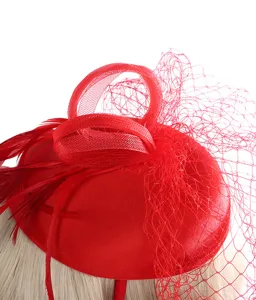 Red fascinator hat with mesh veil and feathers, elegant vintage hair accessory for women.