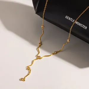 Nahaufnahme einer vergoldeten Edelstahl Zirkon Wellen Y-Halskette mit funkelnden Steinen.