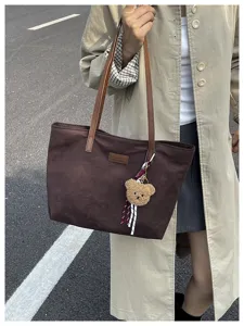 Spacious brown tote bag with cute bear pendant, stylish commuter shoulder bag for women.