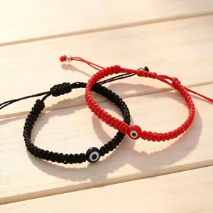 Handmade evil eye woven rope bracelets in black and red, adjustable couple jewelry detail.
