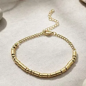 Close-up detail of gold stainless steel Morse code beaded bracelet with adjustable chain.