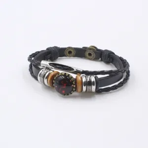 Detail view of multi-layer leather bracelet featuring vintage copper tubes and glass gemstone.