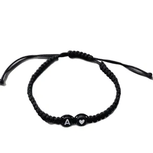 Handgemaakte zwarte gevlochten armband met beginletter A en hartje bedel hoofdaanzicht.