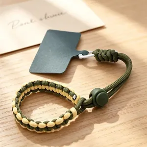 Detailed view of adjustable woven phone wrist strap in green and beige with connector.