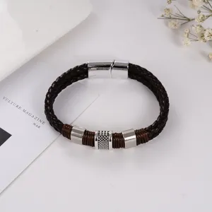 Vista detallada de la pulsera de cuero trenzado marrón con cierre magnético plateado.