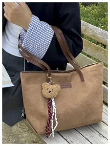 Casual large capacity tote bag with cute bear keychain for women commuting and daily use.