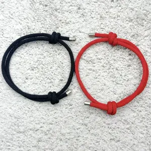 Handmade adjustable braided couple rope bracelets in black and red with metal caps.