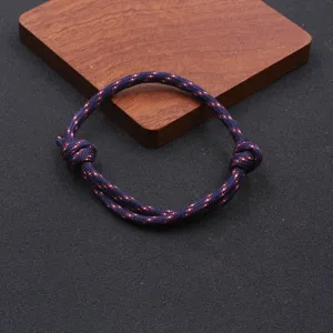 Detailed view of handmade adjustable paracord bracelet with navy blue red speckled nylon cord.