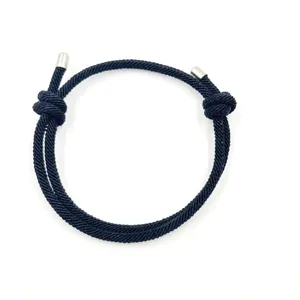 Handmade black woven rope adjustable bracelet detail, minimalist couple wristband accessory.