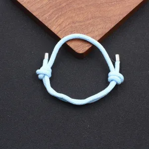 Light blue woven Milan cord bracelet detail featuring adjustable knot and sleek metal tips.