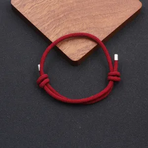 Handmade red woven adjustable bracelet detail, minimalist rope jewelry for men and women.