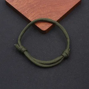 Green paracord braided bracelet detail, adjustable nautical nylon rope for daily wear.