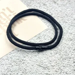 Detailed view of the black woven cord bracelet featuring a secure metallic magnetic clasp design.