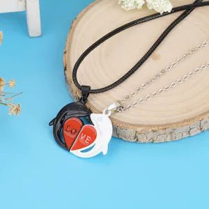 Detailed view of magnetic couple dolphin necklaces with split red heart and love text pendant.