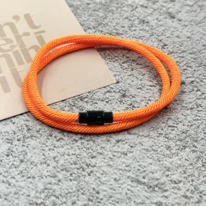 Orange braided rope bracelet with black magnetic clasp, trendy couple jewelry accessory.