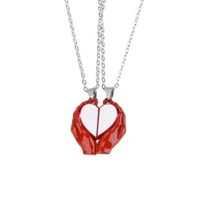 Detailed shot of magnetic couple necklace featuring red hands holding half hearts in alloy.