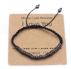 Handmade wooden bead Morse code bracelet detail with adjustable cord on kraft display card.