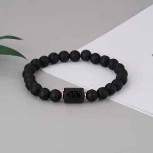 Schwarzes mattes Perlenarmband mit graviertem Stier Sternzeichen Perle und goldenen Ringen.