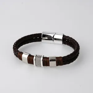 Primer plano de pulsera de cuero trenzado marrón con cierre magnético metálico y anillos.
