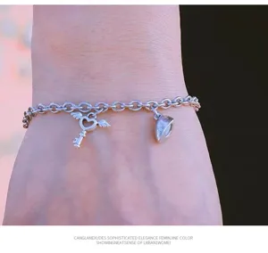 Bracciale di coppia in acciaio inossidabile con charm cuore magnetico e chiave, design minimal.