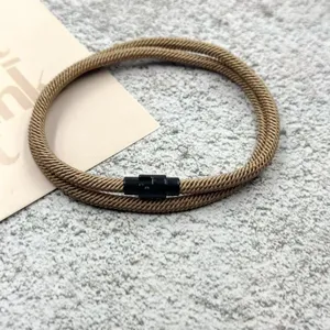 Close-up of brown woven double-layer bracelet with black magnetic clasp, detailed texture.