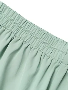 Lichtgroene casual broek elastische hoge taille detail close-up zachte stof elegante stijl