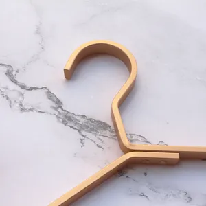 Golden metal clothes hanger hook detail, premium aluminum alloy wire design for wardrobe.