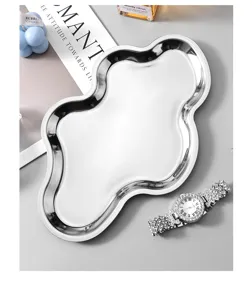 Gros plan d'un plateau en métal argenté de forme nuage irrégulière avec une finition brillante.
