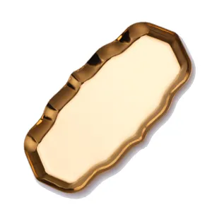Gold metal tray with wavy edges for scented candle tools organization and home decor display.