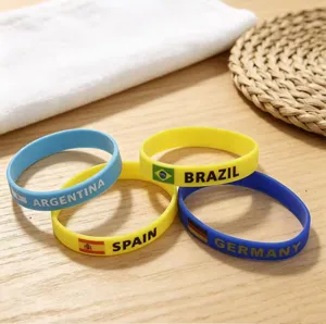 Detailed close-up of colorful silicone wristbands featuring national flags and country names.