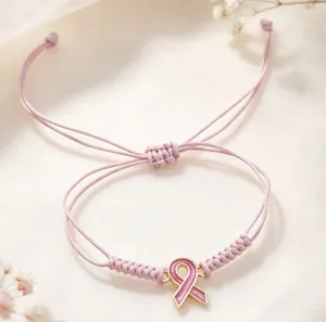 Gros plan détaillé du bracelet en corde tressée rose avec pendentif ruban, finition soignée.