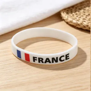 Silicone wristband detail featuring France flag design and clear text print on textured wood.